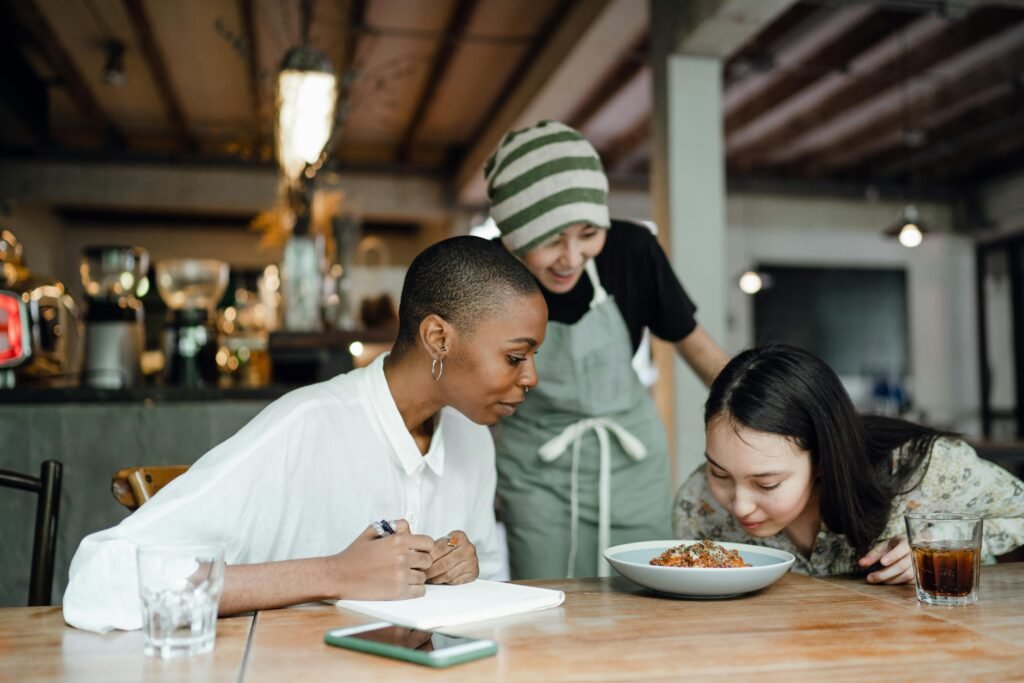 pexels-photo-4350107-4350107 Diverse group of women enjoying a meal together in a cozy café setting.