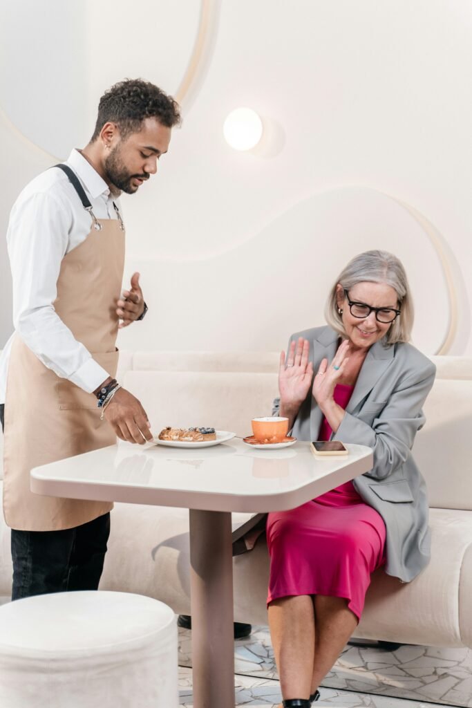 pexels-photo-8790963-8790963 Elderly woman in a café being served by a waiter, capturing a moment of hospitality.