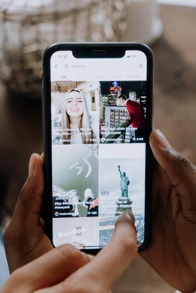 pexels-photo-5081917-5081917 Close-up of a person using a smartphone to browse a social media app indoors.